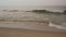 Cute little happy child playing and splashing in sea waves, healthy girl running