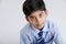 Cute little Indian/Asian school boy showing note book over white background