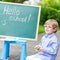 Cute little kid boy with glasses at blackboard practicing writin