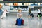 Cute little kid boy with luggage, two suitcases on international airport. Mother with little girl daughter on background