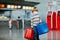 Cute little kid boy with medical mask and luggage, two suitcases on international airport. Mother with little girl