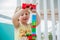 Cute little kid boy playing with lots of colorful plastic blocks indoor. Active child having fun with building and