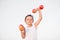 Cute little kid lifting overhead dumbbells made from apples