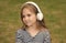Cute little kid listen to audio language course in headphones outdoors, english