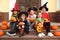 Cute little kids with pumpkins wearing Halloween costumes on stairs outdoors