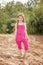 Cute little model posing in pink overall at beach