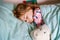 Cute little preschool girl sleeping in bed. Tired preschool child dreaming, healthy sleep of children. Hugging with soft