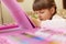 Cute little preschool kid drawing picture with art set, painting with wax crayons, looking concentrated, tries doing best,