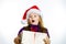 Cute little preschooler girl in red santa hat with gift box