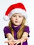 Cute little preschooler girl in red santa hat with gift box