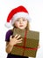 Cute little preschooler girl in red santa hat with gift box