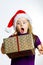Cute little preschooler girl in red santa hat with gift box