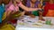 Cute little pupils painting with their hands in classroom