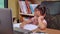 Cute little schoolgirl studying homework math during her online lesson at home, social distancing during the coronavirus outbreak.