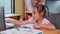 Cute little schoolgirl studying homework math during her online lesson at home, social distancing during the coronavirus outbreak.