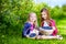 Cute little sisters picking fresh berries on organic blueberry farm