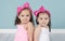 Cute little sisters in pink headbands