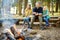 Cute little sisters and their father roasting marshmallows on sticks at bonfire. Children having fun at camp fire. Camping with