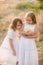 Cute little sisters in white dresses laugh laughing with apples and pears in the countryside on a autumn day