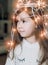 Cute little smiling girl with christmas luminous garland on her head. Christmas holiday portrait child