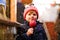Cute little smiling preschool boy on German Christmas market. Happy child in winter clothes eating sweet sugared glazed