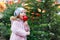 Cute little smiling preschool girl on German Christmas market. Happy child in winter clothes eating sweet sugared glazed