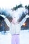 Cute little teenage girl having fun playing with snowballs, ready to throw the snowball