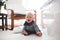 Cute little toddler baby boy, playing at home on the floor in be