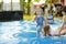 Cute little toddler boy bouncing on huge water filled jumping pillow. Boy jumping up and down on bouncy pad. Active family leisure