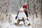 Cute little toddler boy and his older brothers, playing outdoors with snow on a winter day