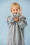 Cute little toddler boy in a huge oversized grey longsleeve over blue