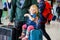 Cute little toddler girl and father at the airport. Happy family traveling by plane, making vacations. Young dad and