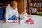 Cute little toddler girl and grandmother playing with toys at home. Adorable baby child and senior retired woman