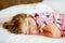 Cute little toddler girl sleeping in bed. Adorable baby child dreaming, healthy sleep of children by day. Deep sleeping