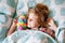 Cute little toddler girl sleeping in bed with favourite soft plush stuffed toy. Adorable preschool child dreaming