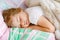 Cute little toddler girl sleeping in bed. Tired preschool child dreaming, healthy sleep of children by day.