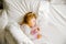 Cute little toddler girl sleeping in big bed of parents. Adorable baby child dreaming in hotel bed on family vacations
