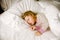 Cute little toddler girl sleeping in big bed of parents. Adorable baby child dreaming in hotel bed on family vacations