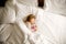 Cute little toddler girl sleeping in big bed of parents. Adorable baby child dreaming in hotel bed on family vacations