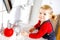 Cute little toddler girl washing hands with soap and water in bathroom. Adorable child learning cleaning body parts