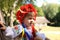 A cute little Ukrainian Caucasian girl in a wreath and an embroidered shirt is resting on a bench