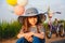 Cute little unhappy girl in big sun hat sitting on road with her bicycle behind her