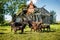Cute lovely angus cow family in front of old neglected farm on grass in sunny day