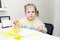 Cute lovely little girl painting with foam brush at home