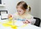 Cute lovely little girl painting with foam brush at home