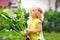 Cute lovely toddler girl with kohlrabi in vegetable garden. Happy gorgeous baby child having fun with first harvest of