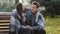 Cute loving couple sit on bench warming each other covering wool blanket outdoors in cold froze autumnal weather feel