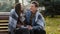 Cute loving couple sit on bench warming each other covering wool blanket outdoors in cold froze autumnal weather feel