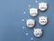Cute macarons in a shape of cats on blue background, small sugar snowflakes around, top view, copy space