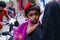 Cute maldivian girl on mother\'s hand looking back